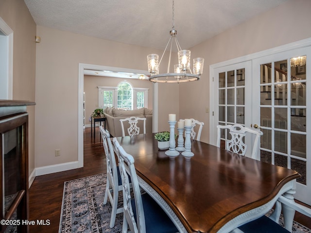 dining room with a notable chandelier, a textured ceiling, and dark hardwood / wood-style flooring