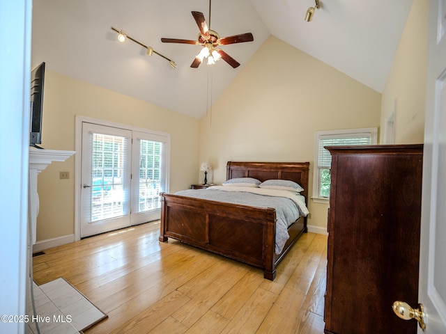 bedroom with high vaulted ceiling, light wood-type flooring, track lighting, ceiling fan, and access to exterior