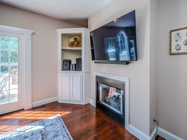 living room with plenty of natural light and dark hardwood / wood-style floors