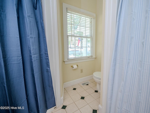 bathroom with toilet and tile patterned flooring