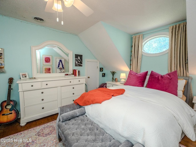 bedroom featuring hardwood / wood-style flooring, vaulted ceiling, a textured ceiling, and ceiling fan