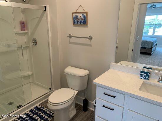 bathroom with vanity, toilet, and a shower with shower door