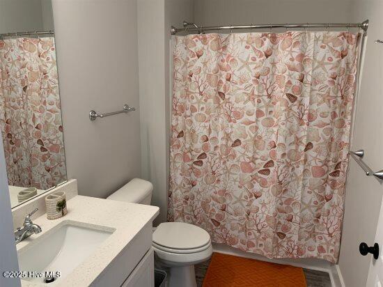 bathroom featuring vanity, toilet, and walk in shower