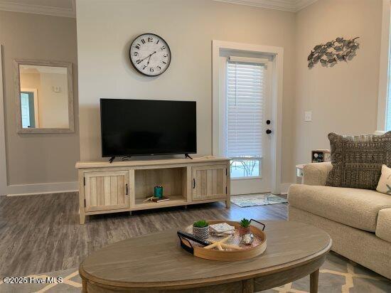 living room with dark wood-type flooring and ornamental molding