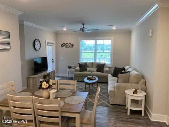 living room with crown molding, ceiling fan, and dark hardwood / wood-style flooring