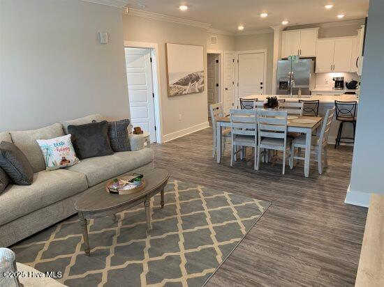 living room with crown molding and dark wood-type flooring