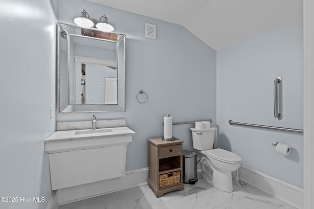 bathroom with vanity, lofted ceiling, and toilet