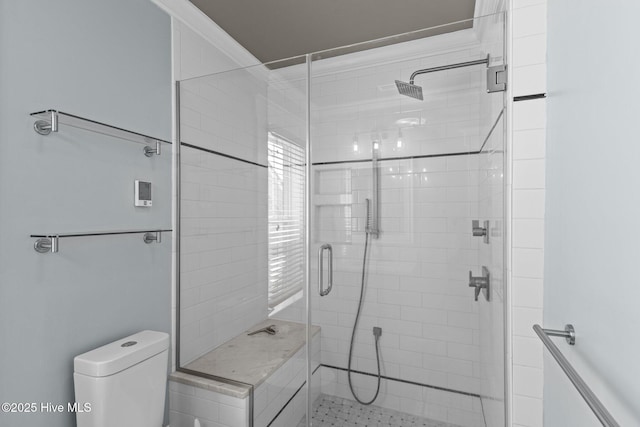 bathroom with a shower with door and toilet