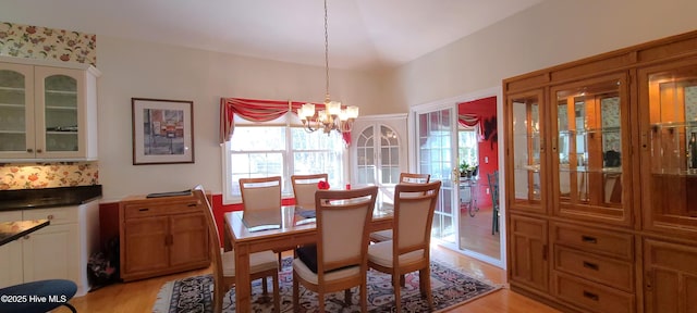 dining space featuring light hardwood / wood-style flooring and a notable chandelier