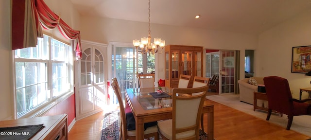 dining area with a chandelier, light hardwood / wood-style floors, and a wealth of natural light