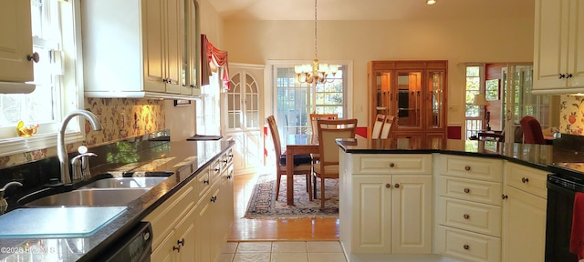 kitchen featuring pendant lighting, sink, light tile patterned floors, an inviting chandelier, and backsplash