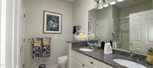 bathroom featuring vanity, toilet, and a shower with shower door