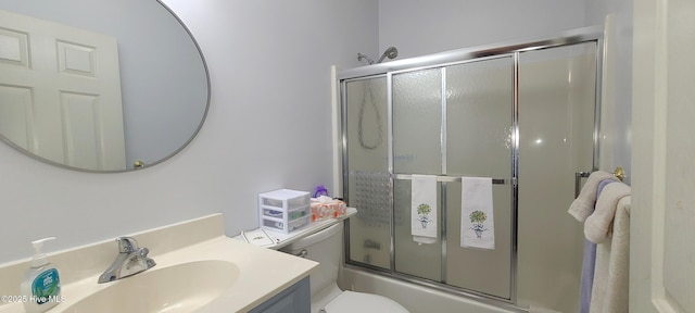 full bathroom featuring vanity, shower / bath combination with glass door, and toilet