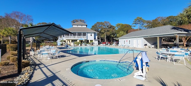 view of pool with a hot tub and a patio area