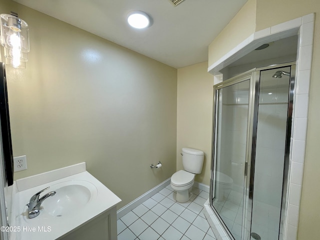 bathroom featuring tile patterned flooring, toilet, vanity, and a shower with shower door