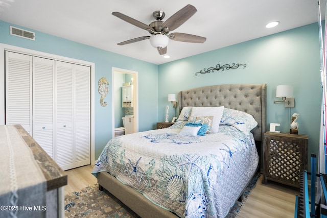 bedroom featuring light hardwood / wood-style flooring, a closet, ceiling fan, and ensuite bathroom