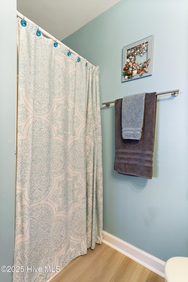 bathroom featuring wood-type flooring and toilet