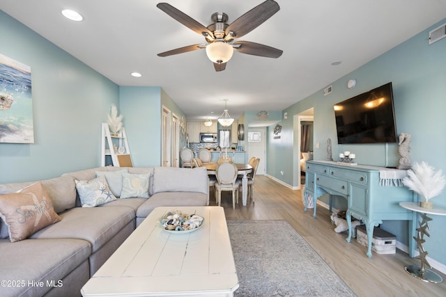 living room featuring light hardwood / wood-style floors and ceiling fan