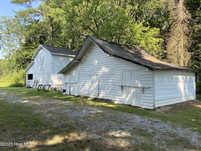 view of side of home with a shed and a yard