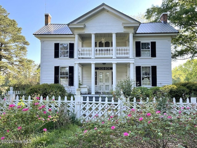 neoclassical home with a balcony and covered porch