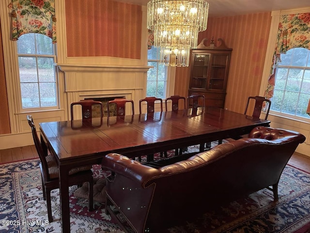 dining room with hardwood / wood-style flooring, plenty of natural light, and a notable chandelier