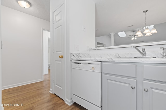 kitchen with white cabinets, hanging light fixtures, sink, and dishwasher