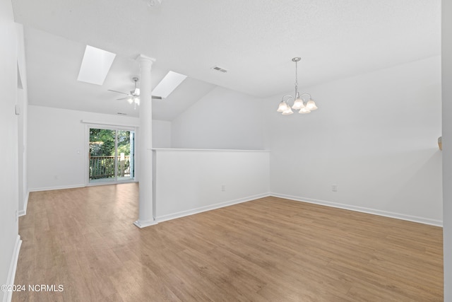 bonus room featuring ceiling fan with notable chandelier, vaulted ceiling with skylight, and light wood-type flooring