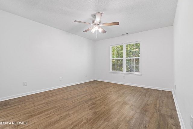 spare room with ceiling fan, wood-type flooring, and a textured ceiling