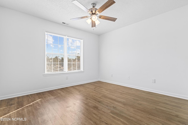 spare room with ceiling fan, dark wood-type flooring, and a textured ceiling