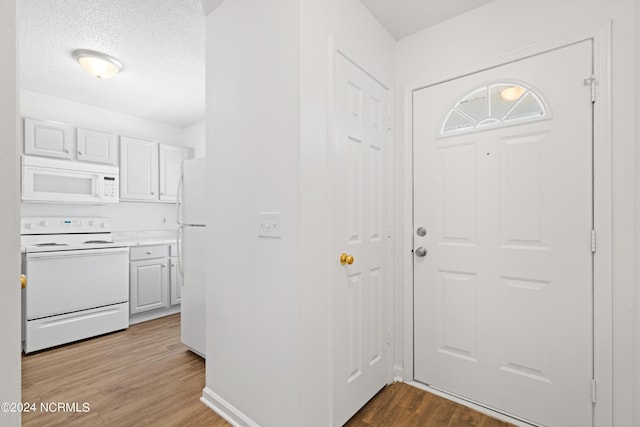 foyer with light hardwood / wood-style floors and a textured ceiling