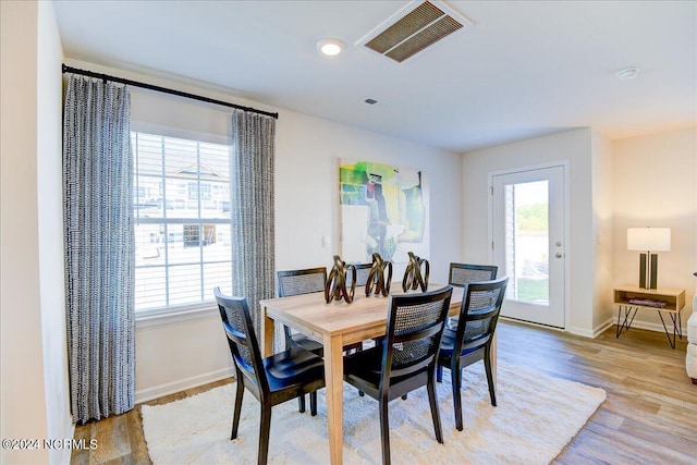 dining space with a wealth of natural light and light hardwood / wood-style flooring