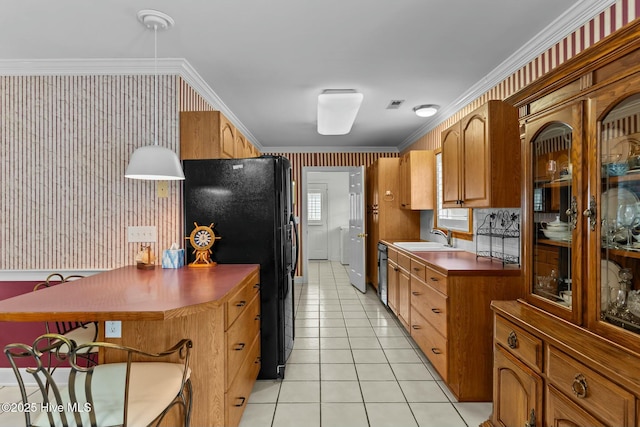 kitchen featuring light tile patterned floors, ornamental molding, sink, and black appliances