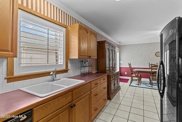 kitchen featuring sink, crown molding, black appliances, light tile patterned flooring, and decorative backsplash