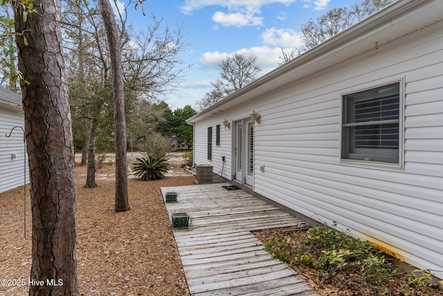 view of side of property with cooling unit and a wooden deck