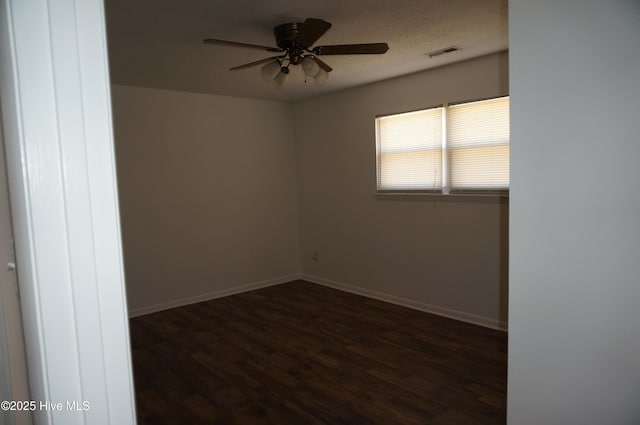 spare room with dark wood-type flooring, a textured ceiling, and ceiling fan