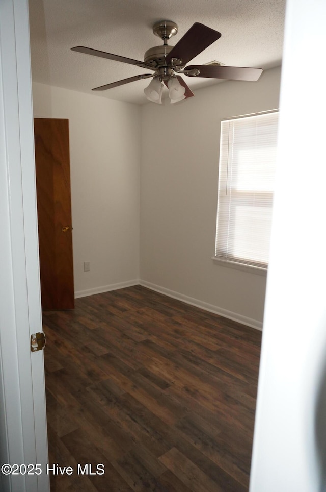 unfurnished room featuring ceiling fan, dark hardwood / wood-style floors, and a textured ceiling