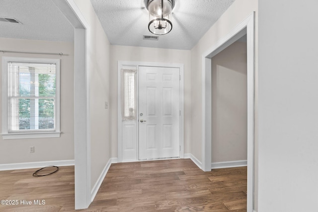 foyer with hardwood / wood-style flooring and a textured ceiling