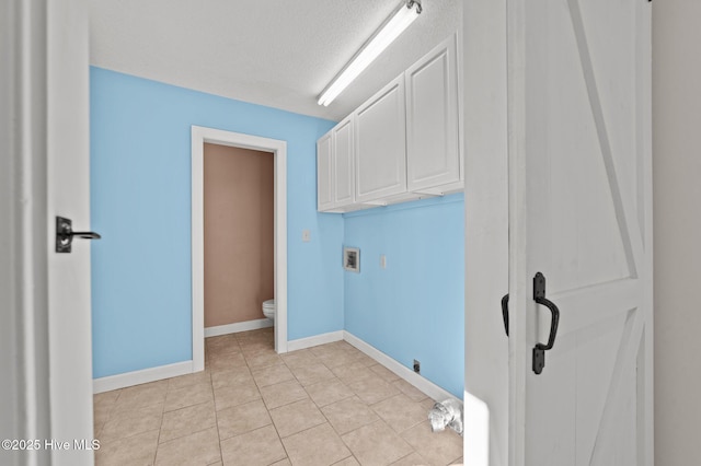 laundry room featuring cabinets, washer hookup, a textured ceiling, and light tile patterned floors