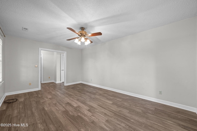 spare room with dark wood-type flooring, a textured ceiling, and ceiling fan