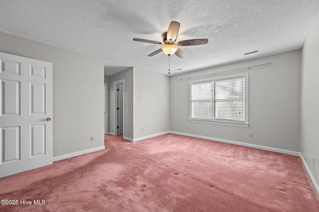 spare room featuring ceiling fan, light colored carpet, and a textured ceiling