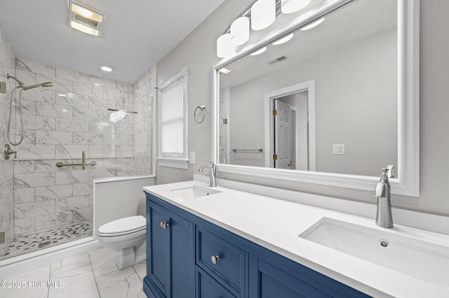 bathroom featuring vanity, tiled shower, and toilet