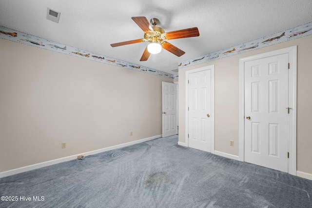 unfurnished bedroom with ceiling fan, carpet floors, and a textured ceiling