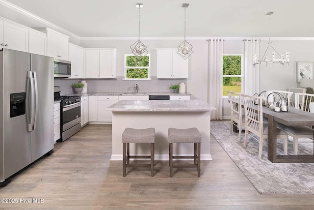 253 Hawks Run Dr Unit 4060, Carolina Shores, NC 28467 - kitchen with stainless steel appliances, crown molding, a kitchen island, white cabinets, and light wood-style floors