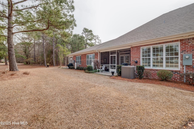 exterior space with a sunroom, a patio area, and central air condition unit