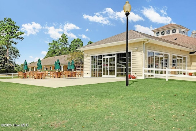 back of house with a lawn and a patio