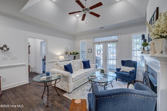 living room featuring dark wood-type flooring, french doors, high vaulted ceiling, a tray ceiling, and ceiling fan