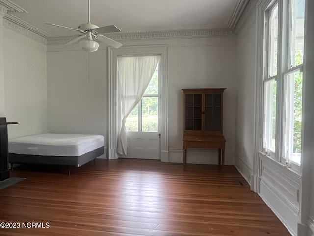 bedroom with wood-type flooring, ceiling fan, and crown molding