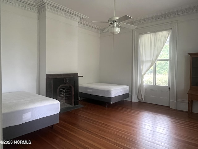 bedroom with dark hardwood / wood-style flooring, crown molding, and ceiling fan