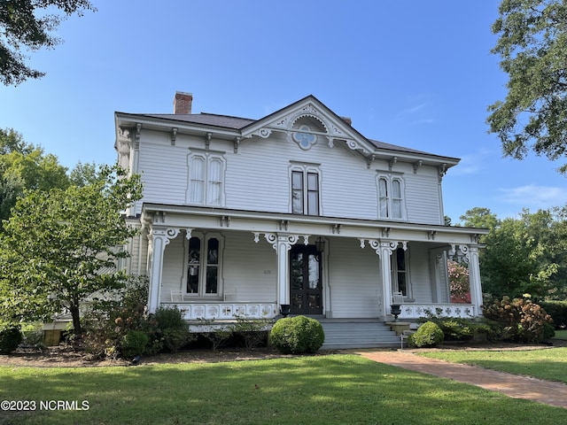 italianate home with covered porch and a front yard