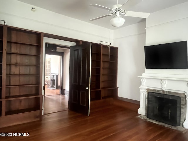 unfurnished living room with dark wood-type flooring and ceiling fan